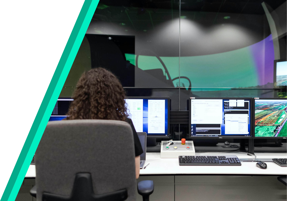 a person sitting in a chair facing backwards toward a computer screen