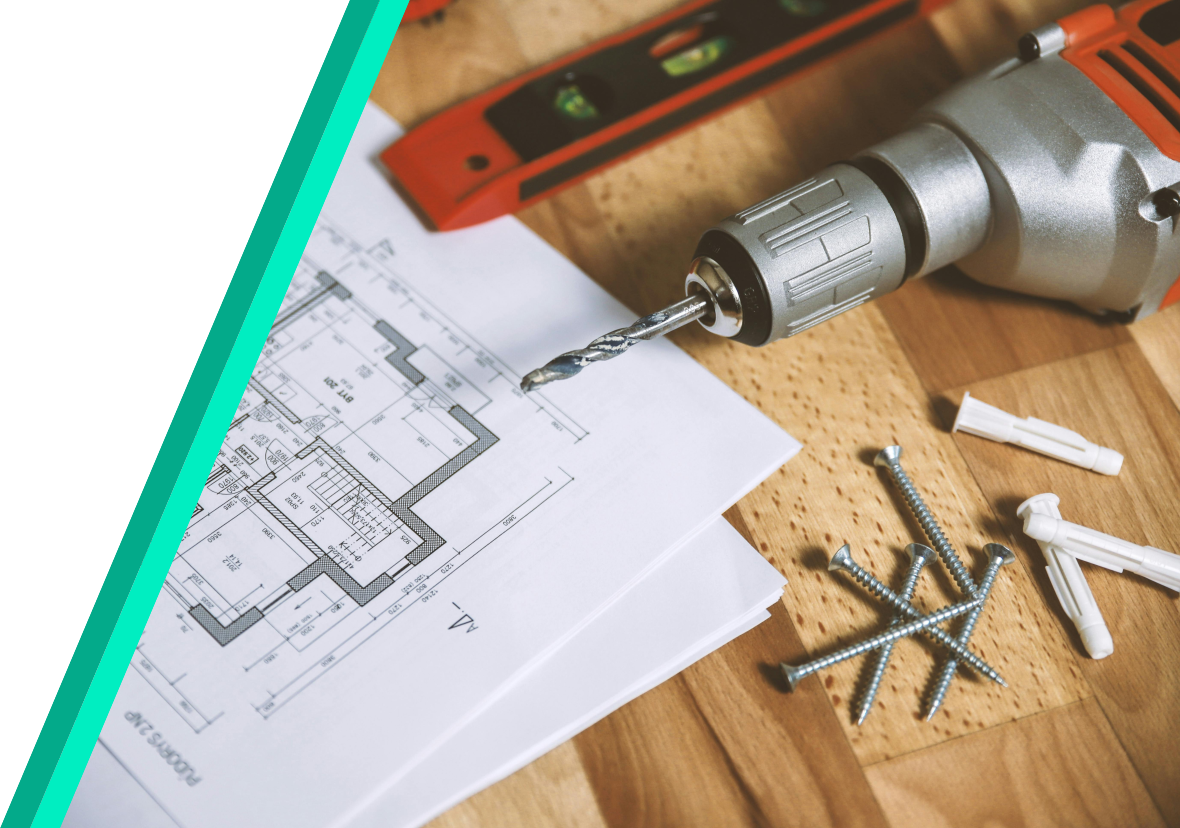 building drawings next to a drill, screws and measuring tape