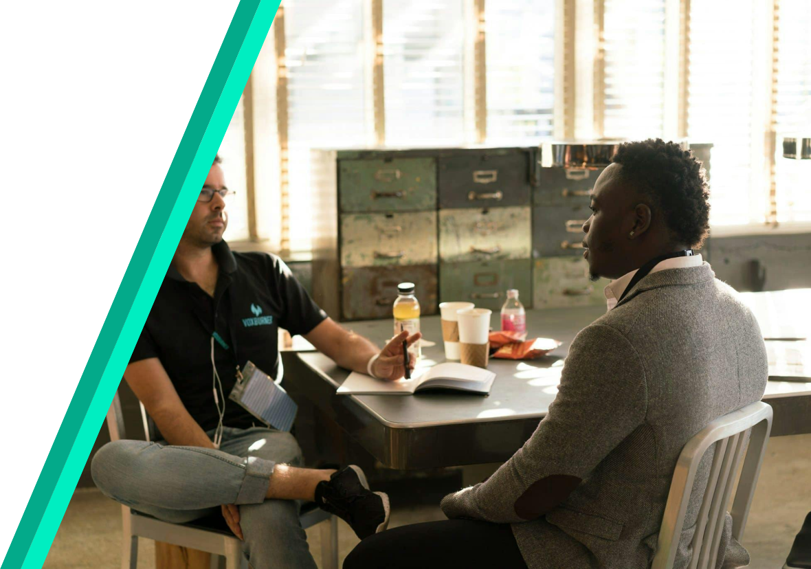 two people in an office sitting at a table facing each other